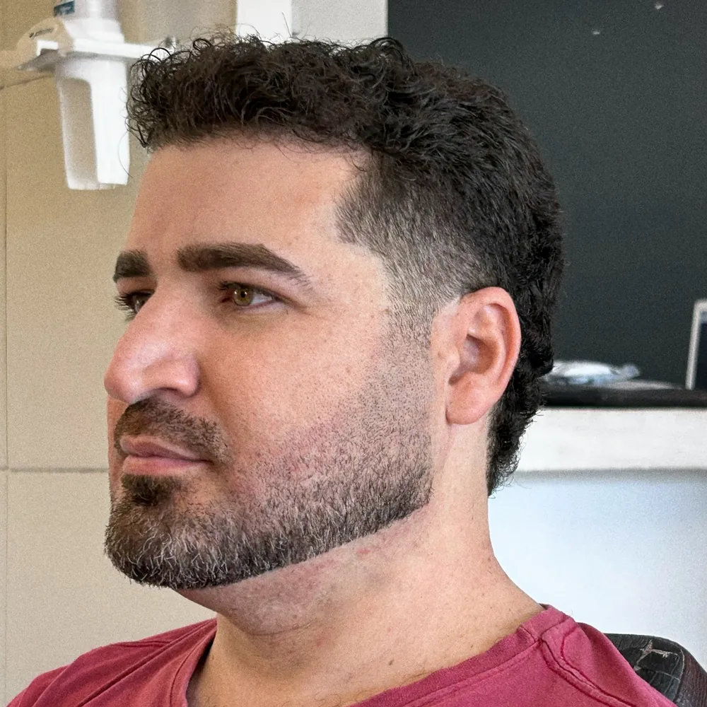 Cliente de cabelo cacheado curto com barba marcada